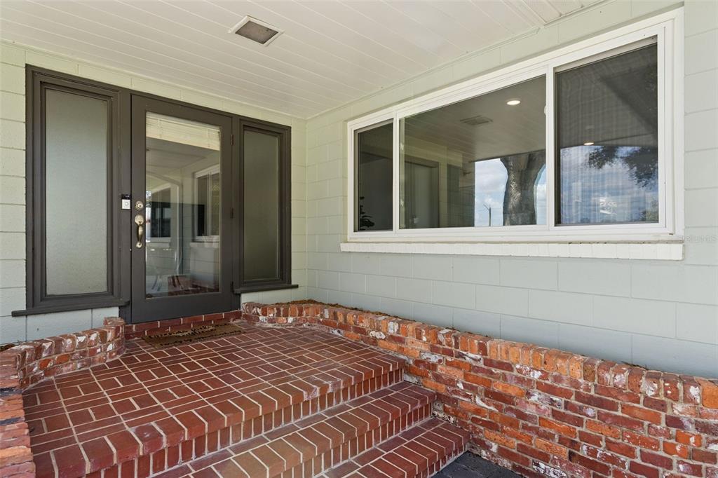 A brick porch with steps leads to a front door and window on a house — 290 CARROLL STREET, CLERMONT, FL