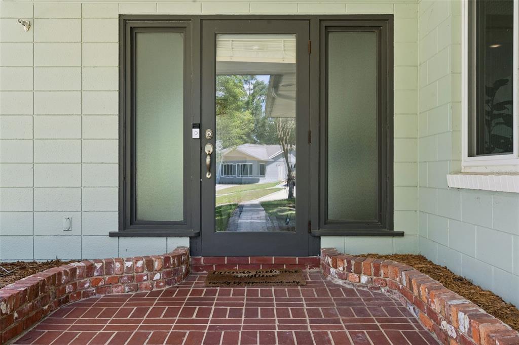A front entryway features a glass-paneled door with sidelights, a brick porch, and light-colored siding — 290 CARROLL STREET, CLERMONT, FL