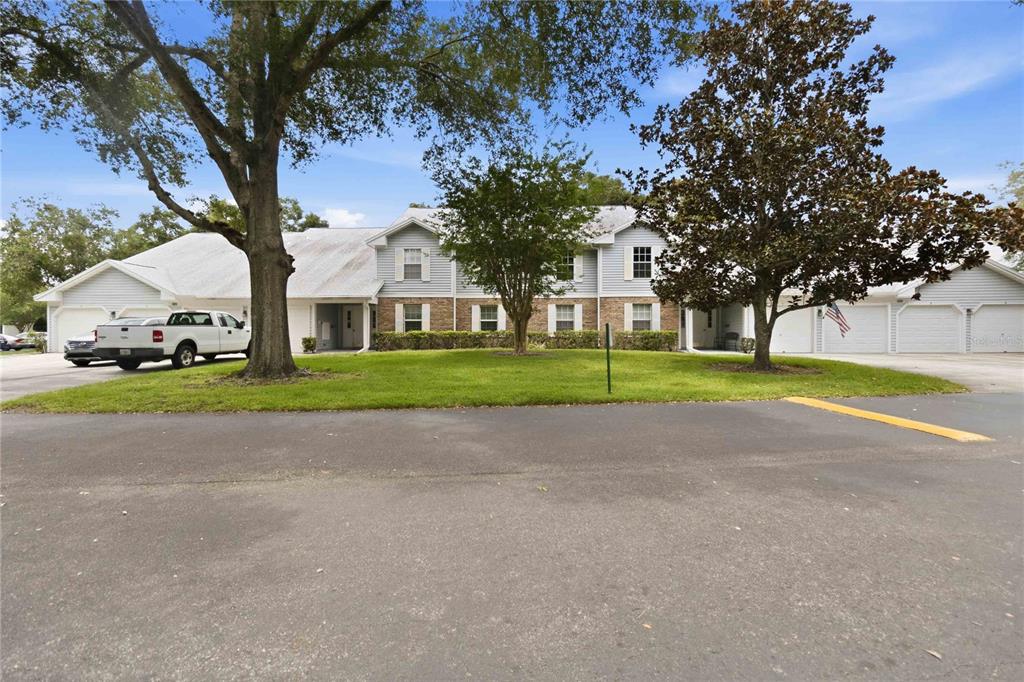 A two-story residential building with a gray roof, light siding, and attached garages — 5278 WHITSTABLE WAY UNIT 5, ORLANDO, FL