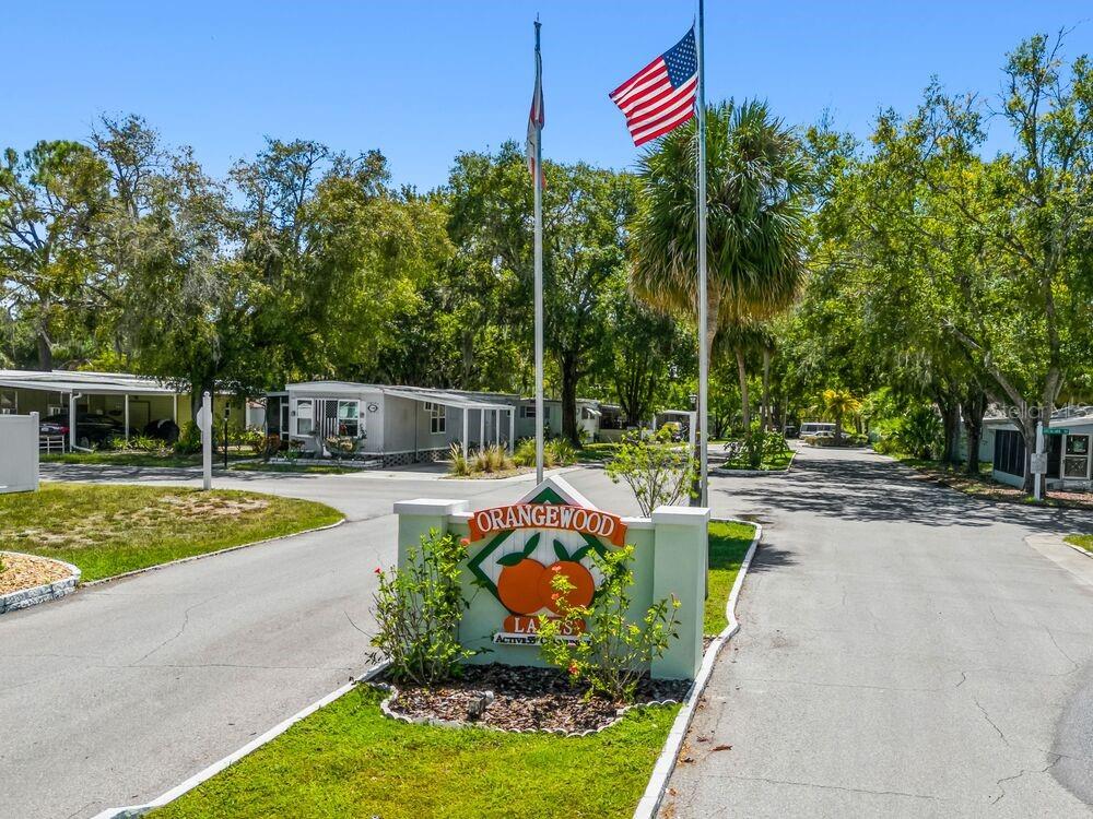 A sign for Orangewood Lakes stands at the entrance of a mobile home community — 6445 BELLE TERRE, NEW PORT RICHEY, FL