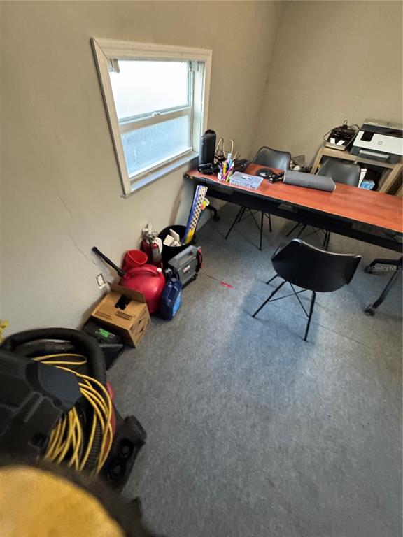 A small office room features a desk, chairs, a window, and various items on the floor — 1050 NURSERY ROAD, WINTER SPRINGS, FL