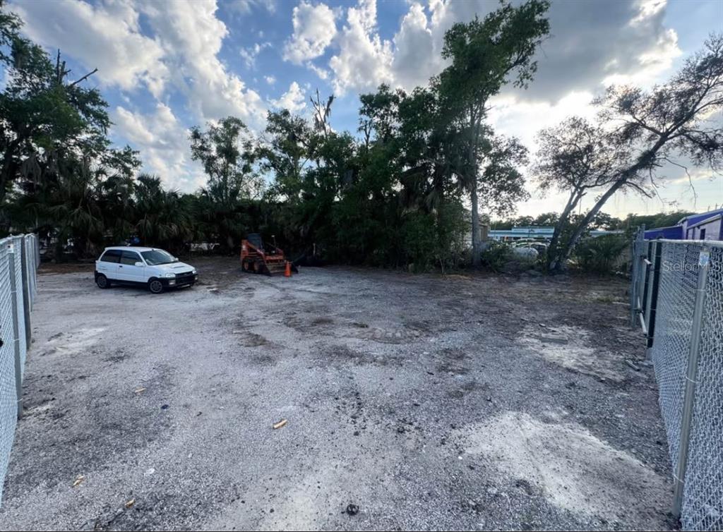 A gravel lot features a white car, a small orange loader, and chain-link fencing — 1050 NURSERY ROAD, WINTER SPRINGS, FL