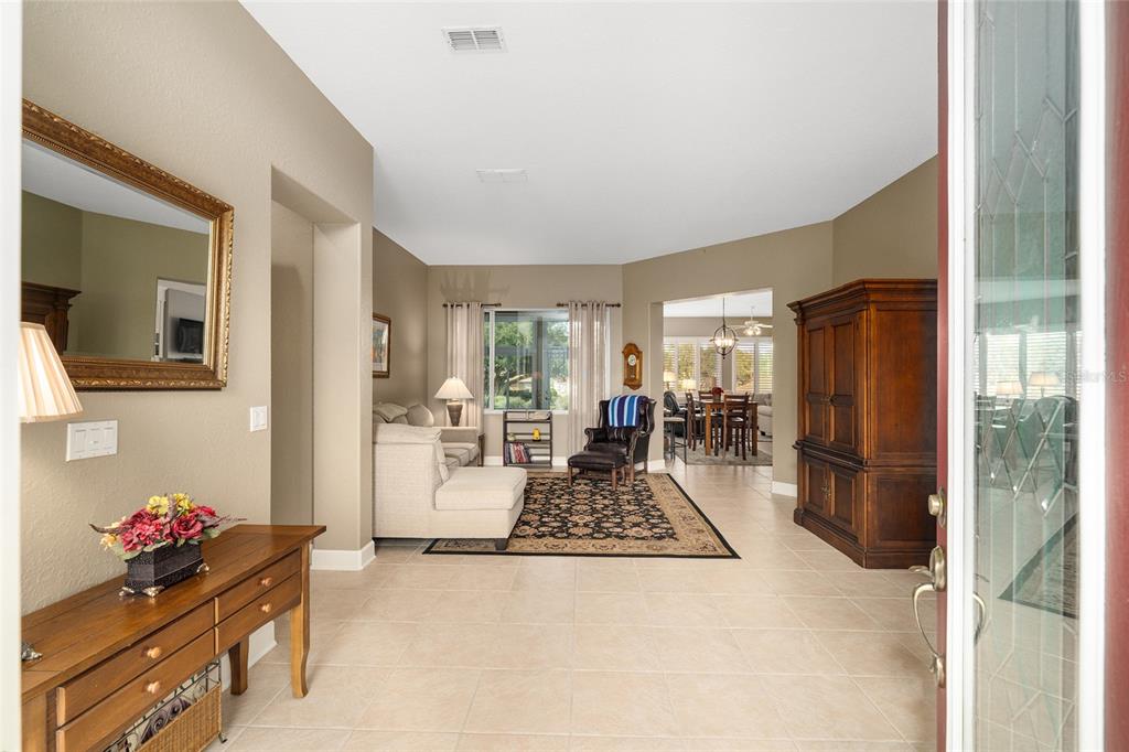 A view from an entryway into a living room with tile floors and neutral walls — 9479 SE 130TH STREET ROAD, SUMMERFIELD, FL