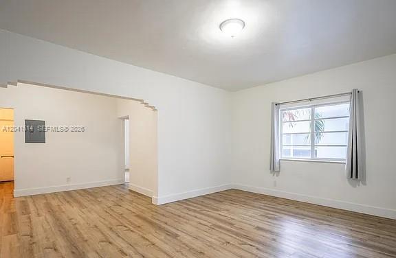 An empty room with white walls, light wood-look flooring, and a window with curtains — 245 79th Street # 2, Miami Beach FL 33141, MIAMI BEACH, FL