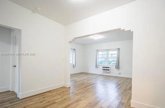 An interior view shows a living room with light wood flooring and an arched entryway — 245 79th Street # 2, Miami Beach FL 33141, MIAMI BEACH, FL