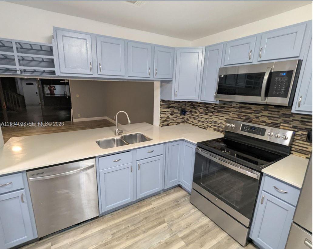 A living room with a sectional sofa, a staircase, and a kitchen breakfast bar — 4430 NW 92nd Way, Sunrise FL 33351, SUNRISE, FL