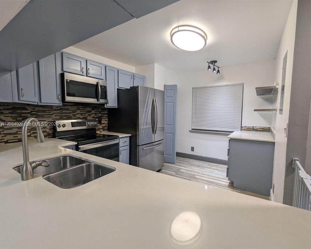 A two-story townhouse with a brick archway entrance, stucco siding, and dark wood trim — 4430 NW 92nd Way, Sunrise FL 33351, SUNRISE, FL