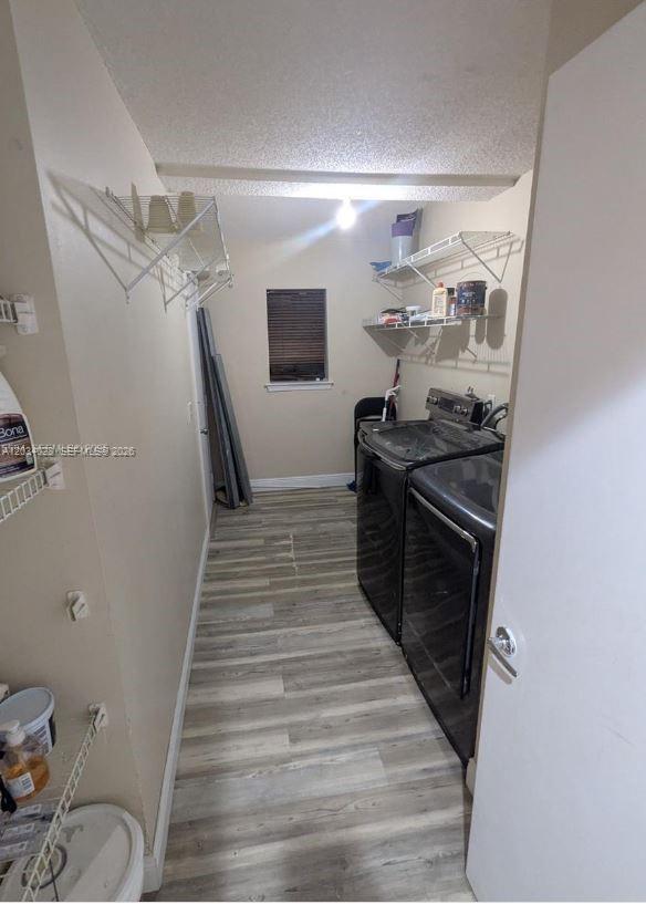 A kitchen features blue cabinets, stainless steel appliances, a tiled backsplash, and wood-look flooring — 4430 NW 92nd Way, Sunrise FL 33351, SUNRISE, FL