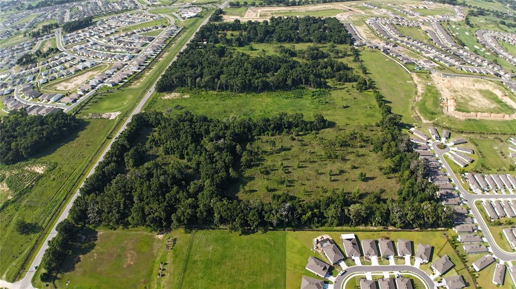 An aerial view shows a large, undeveloped plot of land surrounded by suburban residential neighborhoods — XX SW 80TH AVENUE, OCALA, FL
