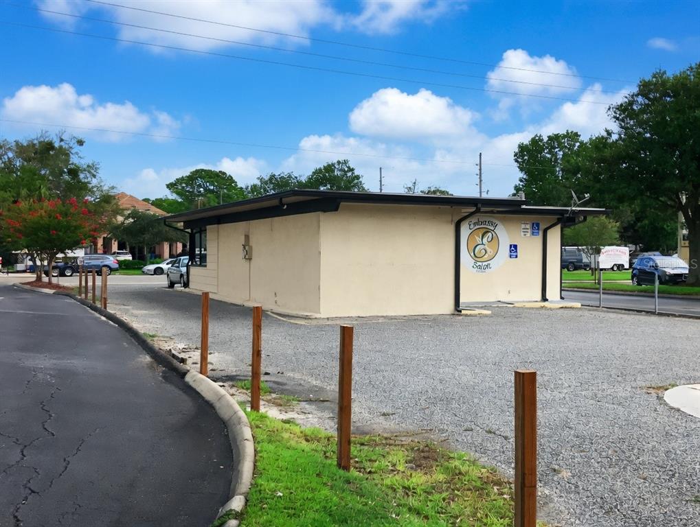 A beige, single-story commercial building with a gravel parking lot and wooden post perimeter — 110 PENMAN ROAD, NEPTUNE BEACH, FL