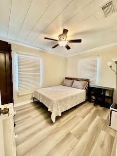A bedroom with light wood-look flooring, a ceiling fan, and a bed near two windows — 304 SE 3rd Avenue, Delray Beach FL 33483, DELRAY BEACH, FL