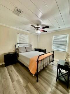 A bedroom features a metal bed frame, wood-look flooring, a ceiling fan, and two nightstands — 304 SE 3rd Avenue, Delray Beach FL 33483, DELRAY BEACH, FL