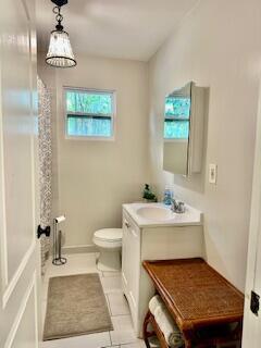 A small bathroom features a white vanity, a toilet, a shower curtain, and a pendant light — 304 SE 3rd Avenue, Delray Beach FL 33483, DELRAY BEACH, FL