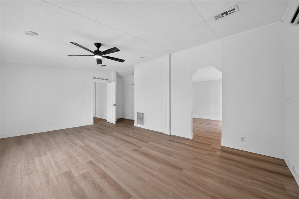 An empty room with white walls, wood-look flooring, and a ceiling fan — 10213 UNION PARK DRIVE, ORLANDO, FL