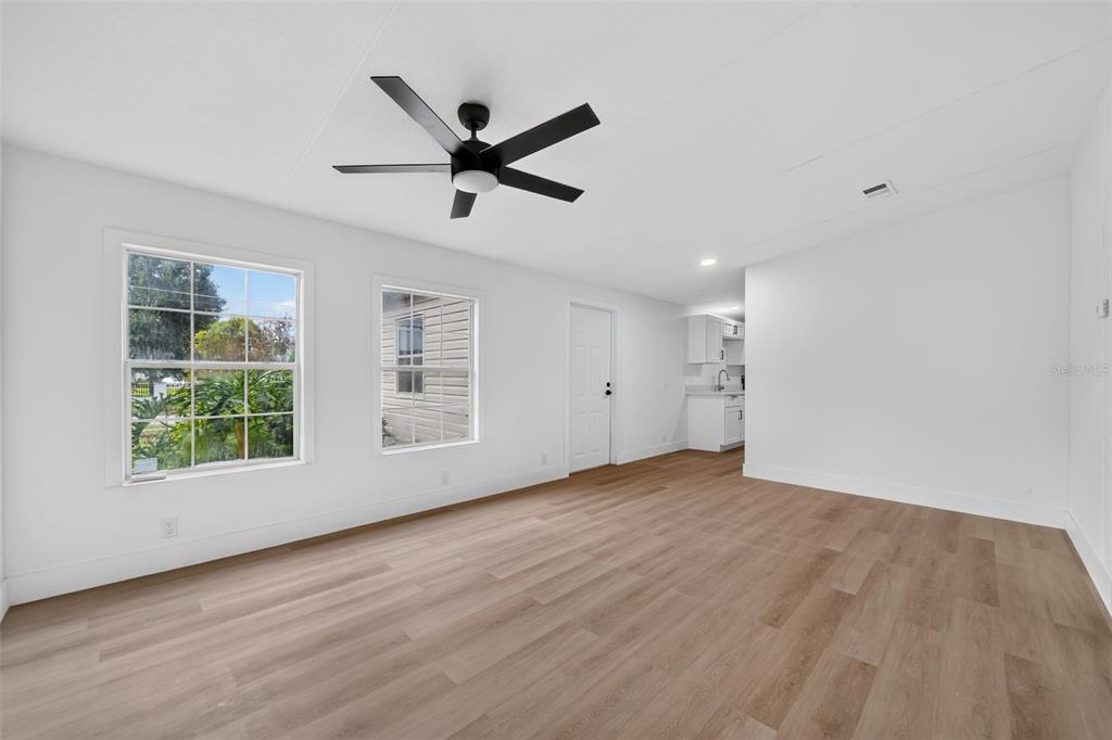 A bright room with light wood-look flooring, a ceiling fan, and a view of outdoors — 10213 UNION PARK DRIVE, ORLANDO, FL