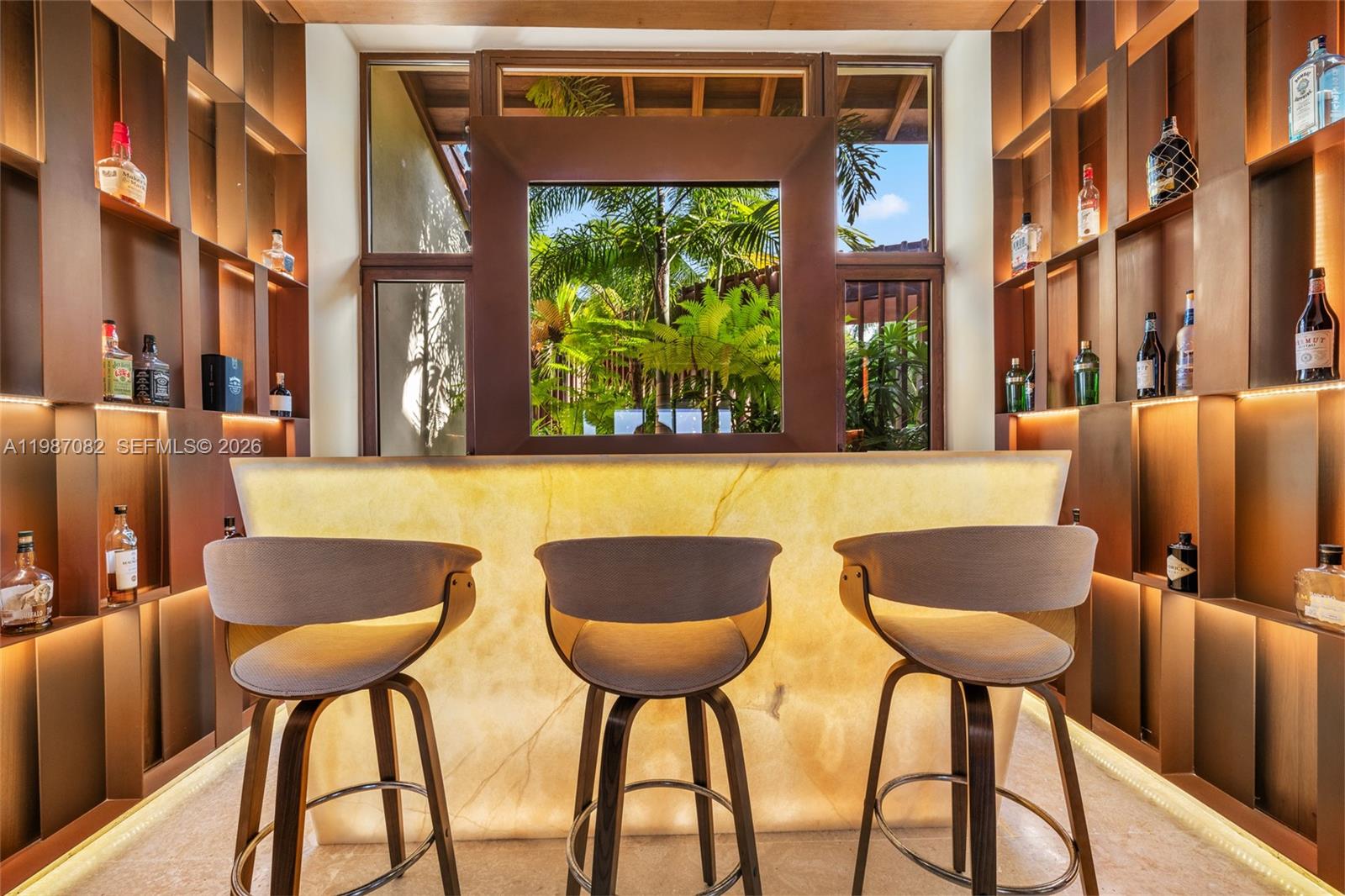 A home bar features an illuminated stone counter, three stools, and backlit wooden shelving — Las Palmas 21 A Casa de Campo, La Romana, Dominic, FL
