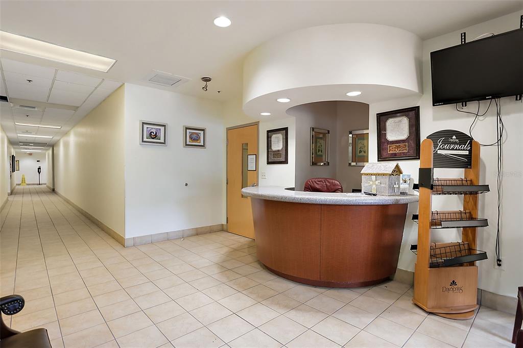 A reception area features a curved wooden desk, tiled floors, and a hallway — 1 S COTTAGE HILL ROAD, ORLANDO, FL