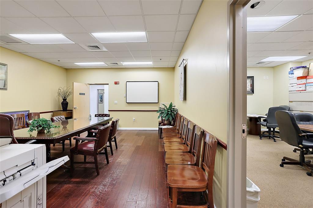 A conference room with a long table and wooden chairs leads into an adjacent office — 1 S COTTAGE HILL ROAD, ORLANDO, FL
