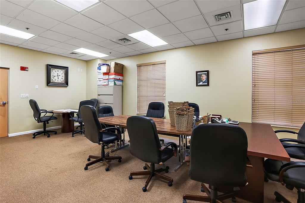 A conference room features a long wooden table, several rolling chairs, and beige walls — 1 S COTTAGE HILL ROAD, ORLANDO, FL