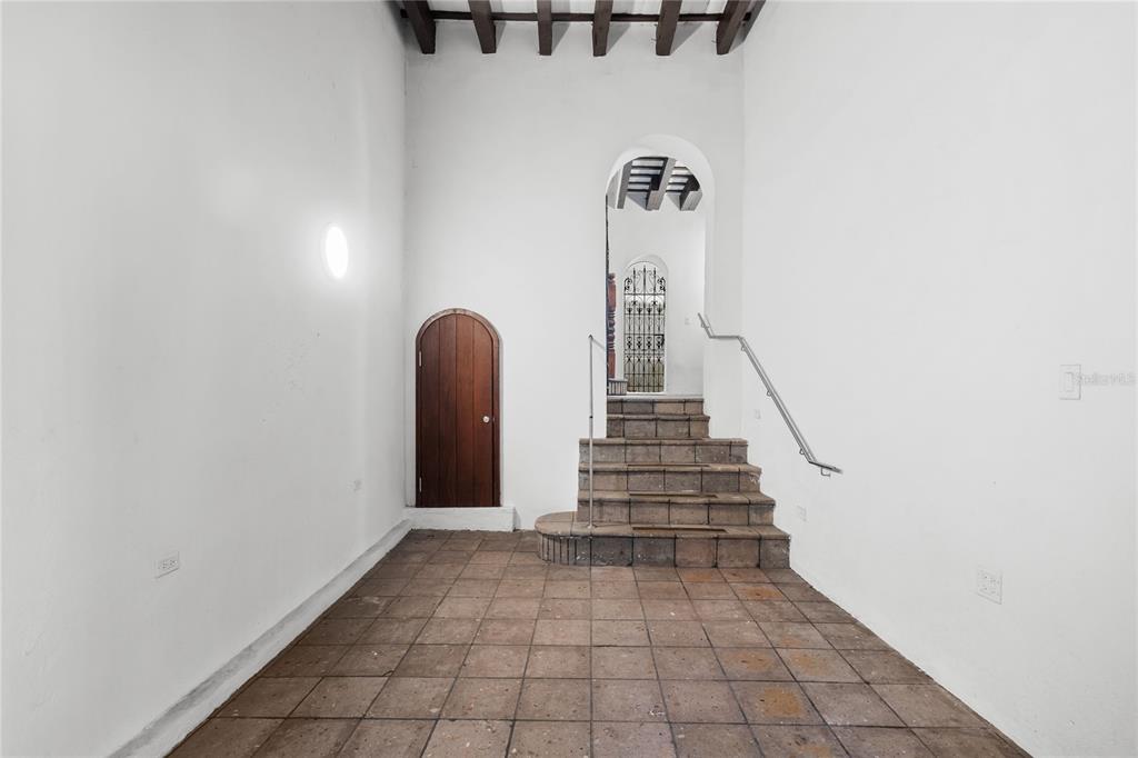 An interior view shows a tiled floor, a wooden arched door, and stone stairs — 70 CALETA DE SAN JUAN UNIT 2, OLD SAN JUAN, PR