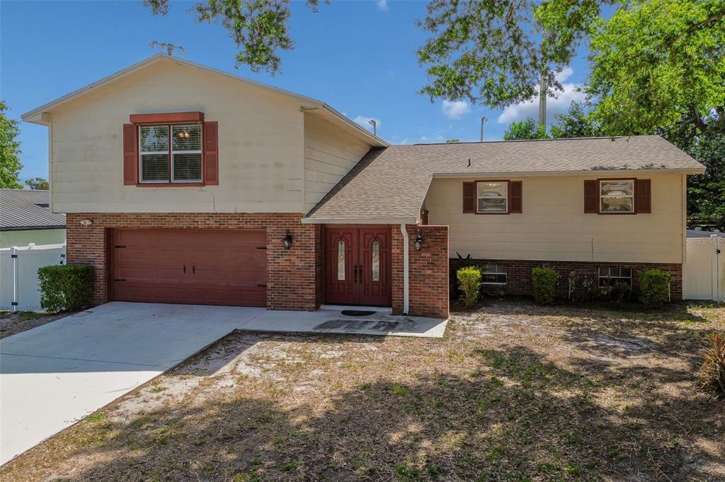 A two-story house with a brick and beige exterior, a garage, and a double front door — 2620 GIANT PLACE, SEFFNER, FL