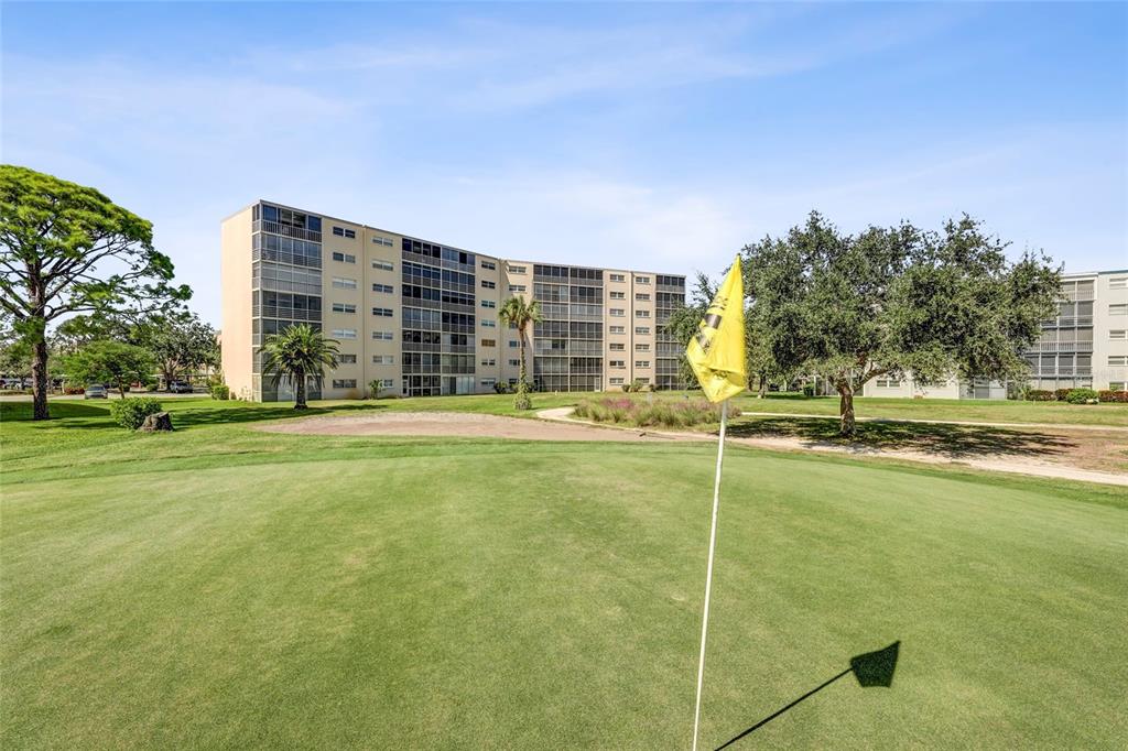 A view of a golf course putting green with a flagstick and a residential building — 4040 IRONWOOD CIRCLE UNIT 406F, BRADENTON, FL
