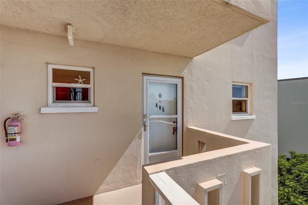 An exterior view of a building entrance with a white door numbered 406 — 4040 IRONWOOD CIRCLE UNIT 406F, BRADENTON, FL