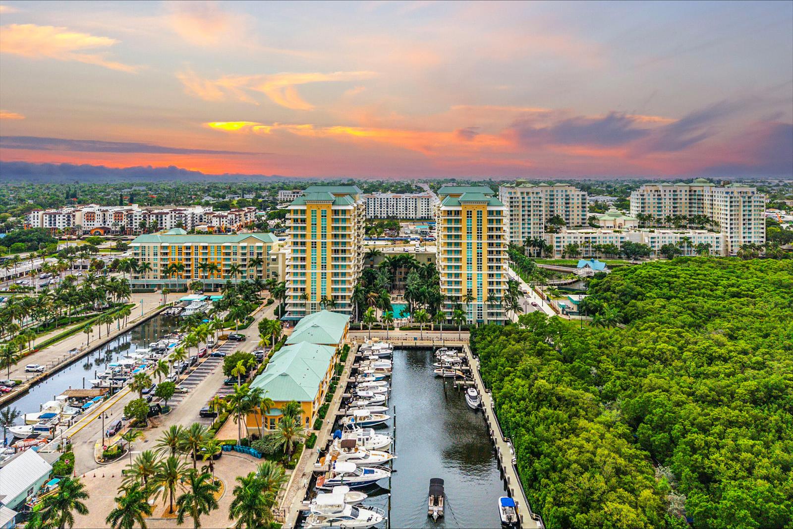An aerial view of a marina with docked boats next to tall residential buildings at sunset — 625 Casa Loma Boulevard # 1408, Boynton Beach FL 33435, BOYNTON BEACH, FL