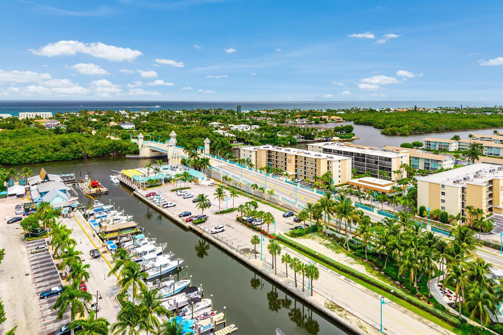 An aerial view shows a marina with docked boats, a bridge, and surrounding coastal buildings — 625 Casa Loma Boulevard # 1408, Boynton Beach FL 33435, BOYNTON BEACH, FL