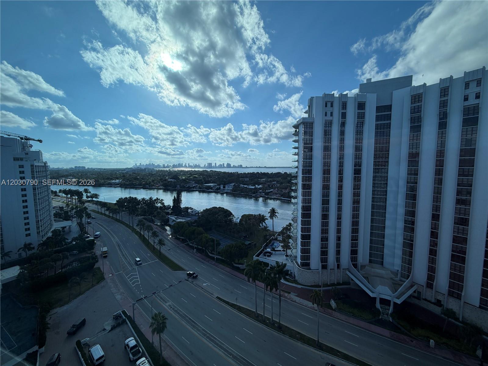 An elevated view shows a multi-lane road, a waterway, and high-rise buildings under a cloudy sky — 5445 Collins Ave # 1506, Miami Beach FL 33140, MIAMI BEACH, FL