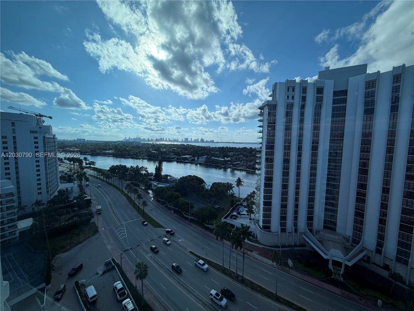 An elevated view shows a multi-lane road, a waterway, and high-rise buildings under a cloudy sky — 5445 Collins Ave # 1506, Miami Beach FL 33140, MIAMI BEACH, FL