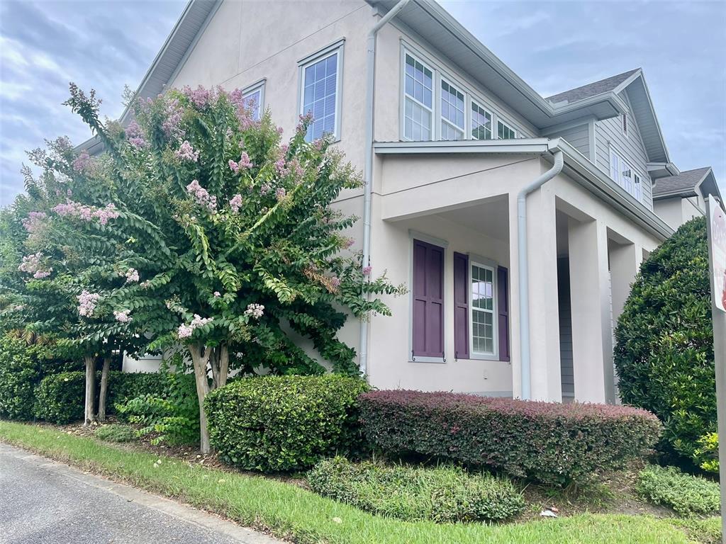A two-story house with a covered porch, purple shutters, and a large flowering crape myrtle — 13892 HEANEY AVENUE, ORLANDO, FL