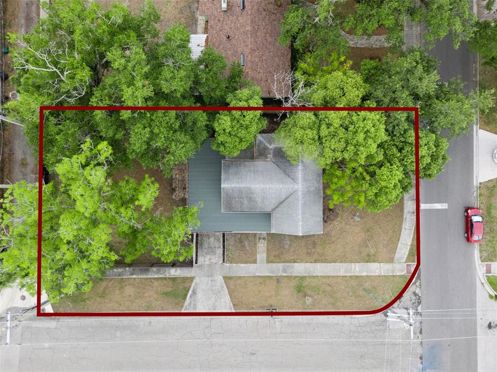 An aerial view shows a house with a green roof surrounded by trees on a corner lot — 417 W 6TH STREET, SANFORD, FL