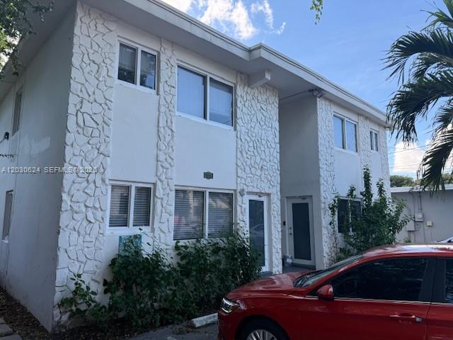 A two-story apartment building features white stucco walls with decorative stone accents and a red car — 2006 Calais Dr # 1, Miami Beach FL 33141, MIAMI BEACH, FL