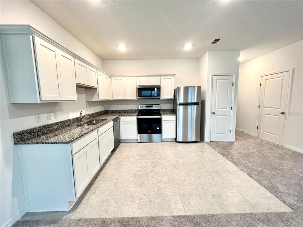 An entryway features a white front door, tiled flooring, and a small window with blinds — 1105 MERRILL STREET, DAVENPORT, FL