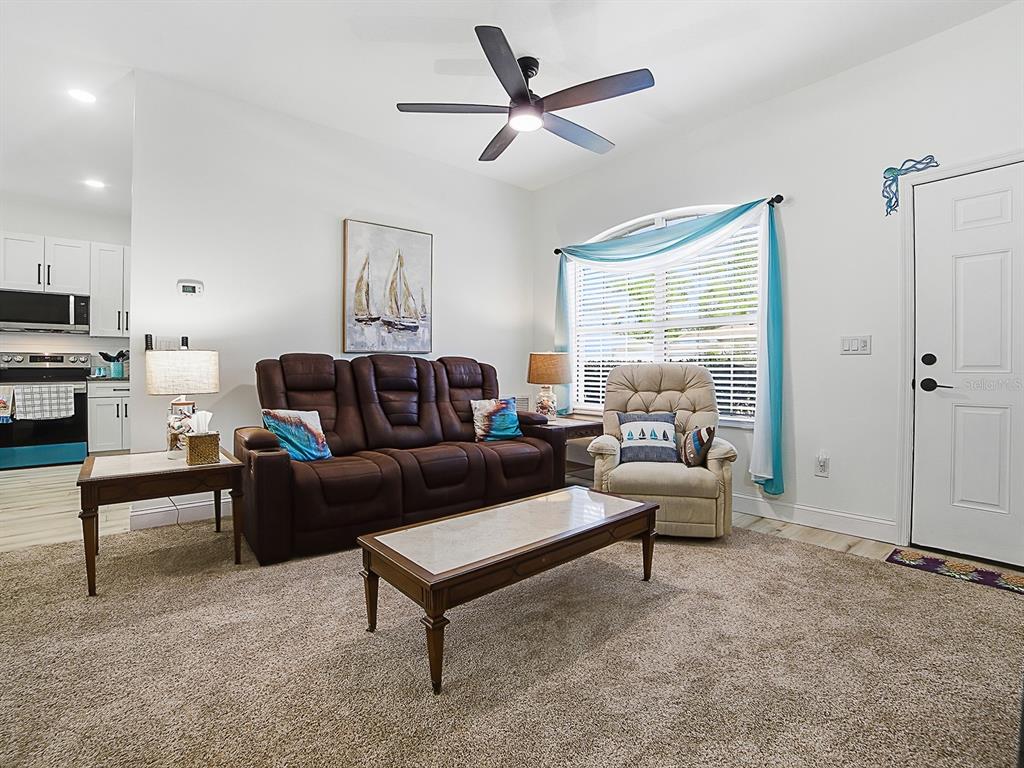 A living room features a brown leather sofa, a beige recliner, and a coffee table — 2632 NE 27TH STREET, OCALA, FL