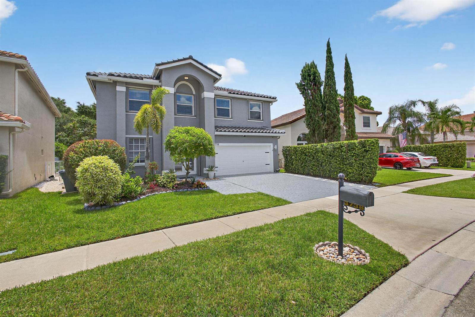 A two-story gray house with a tile roof, a two-car garage, and a front lawn — 3738 Old Lighthouse Circle, Wellington FL 33414, WELLINGTON, FL