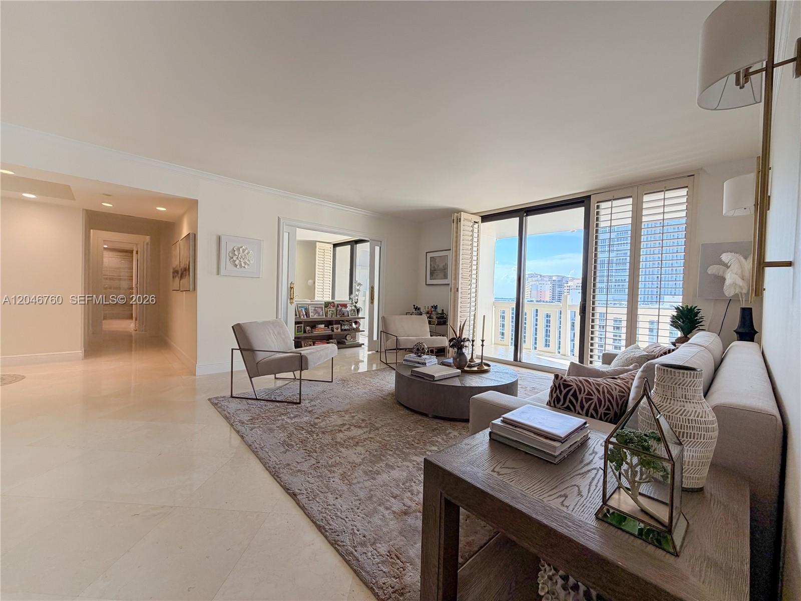 A living room features a beige sofa, two armchairs, a round coffee table, and balcony access — 1111 Crandon Blvd # C1104, Key Biscayne FL 33149, KEY BISCAYNE, FL