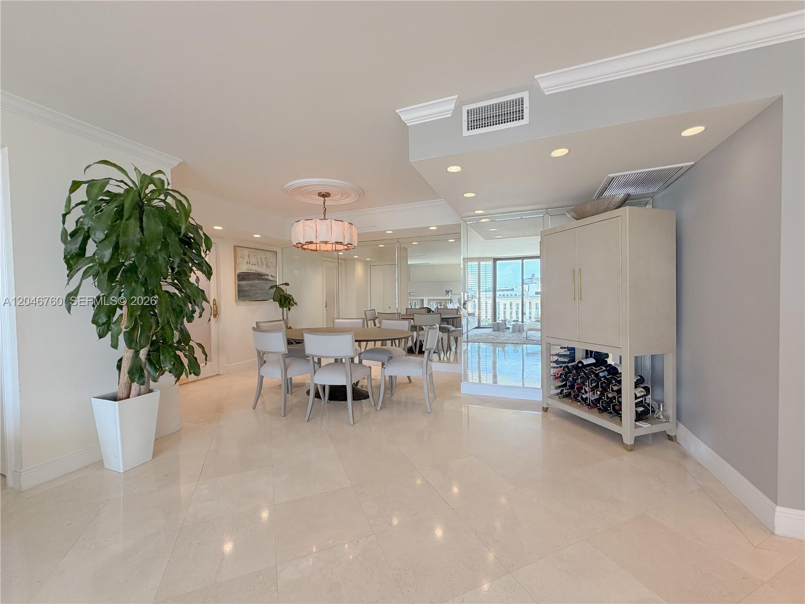 A dining area features a round table, upholstered chairs, a wine cabinet, and tiled floors — 1111 Crandon Blvd # C1104, Key Biscayne FL 33149, KEY BISCAYNE, FL