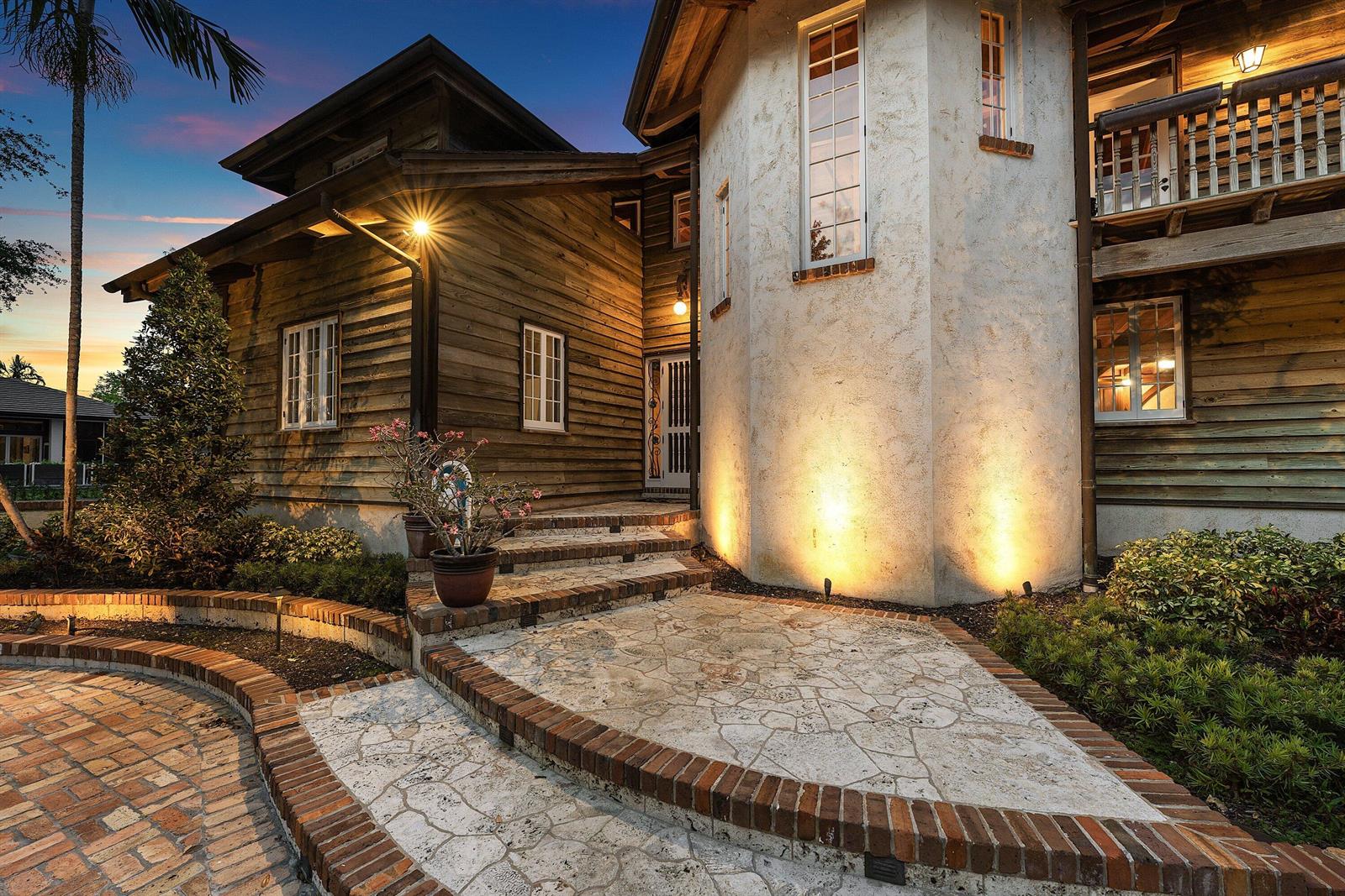 An exterior view of a house with wood siding, a stone tower, and brick stairs — 6002 NW 74th Terrace, Parkland FL 33067, PARKLAND, FL