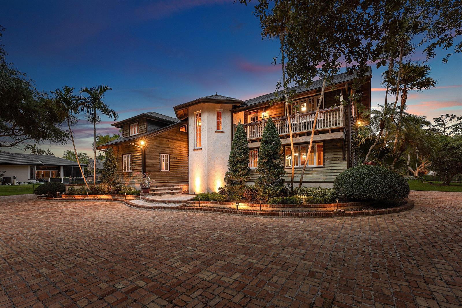 A two-story wood-sided house with a brick driveway and a central white stucco tower — 6002 NW 74th Terrace, Parkland FL 33067, PARKLAND, FL