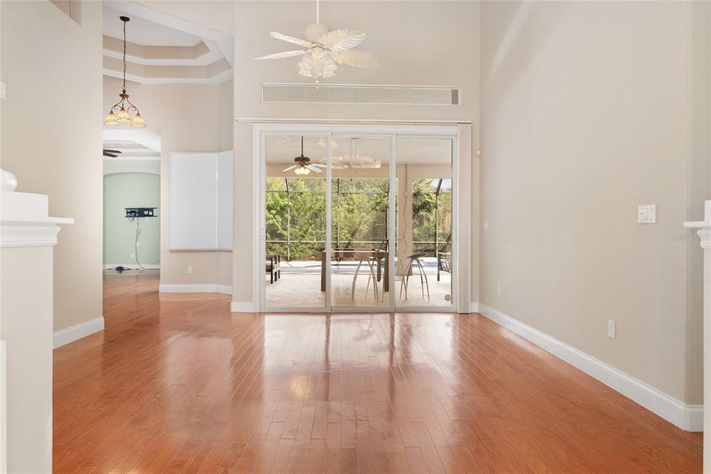 A living room with hardwood floors, a ceiling fan, and sliding glass doors to a patio — 15 OLD OAK DRIVE N, PALM COAST, FL