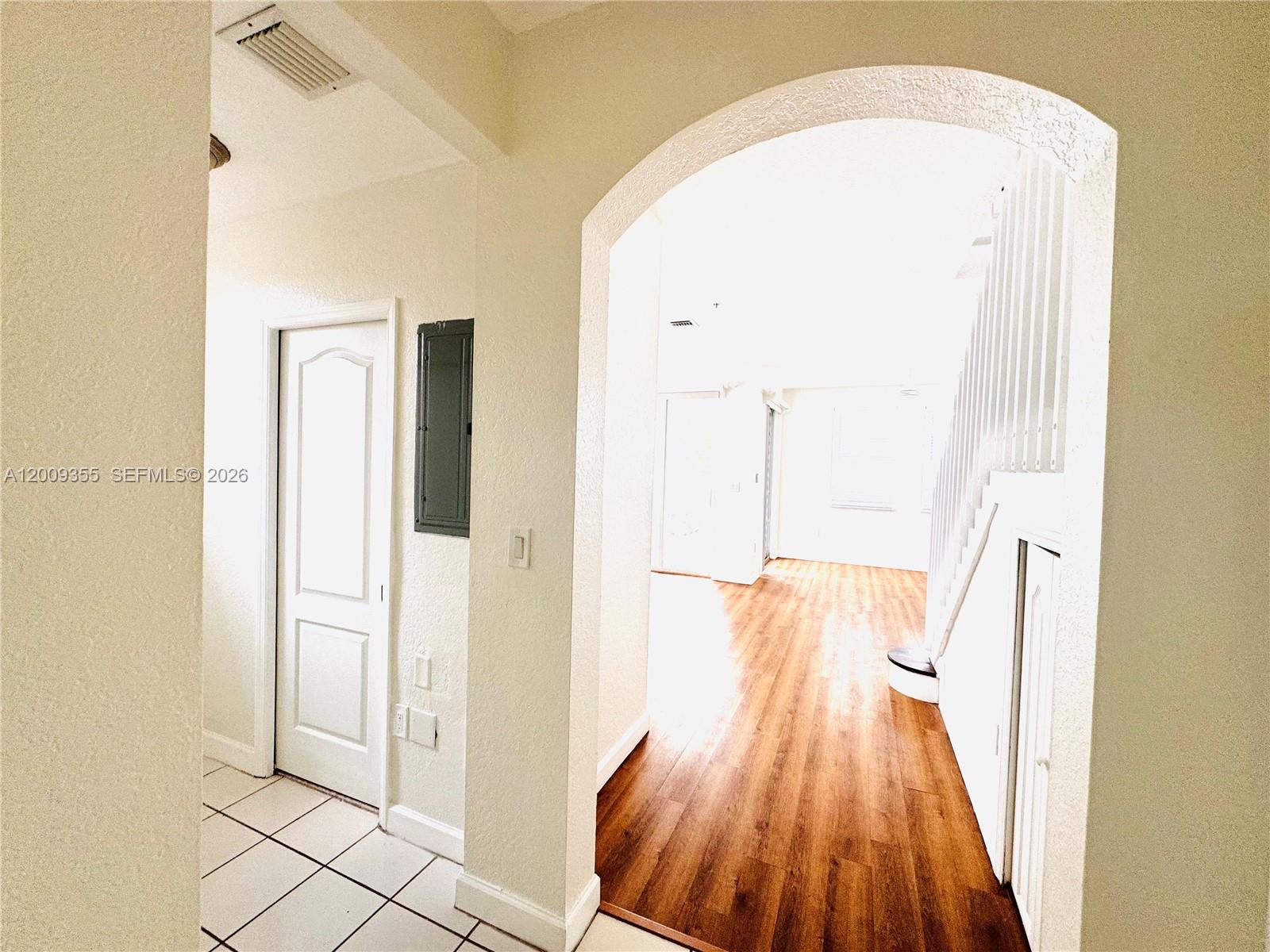An arched entryway leads from a tiled foyer into a living area with wood flooring — 4435 SW 160th Ave # 214, Miramar FL 33027, MIRAMAR, FL