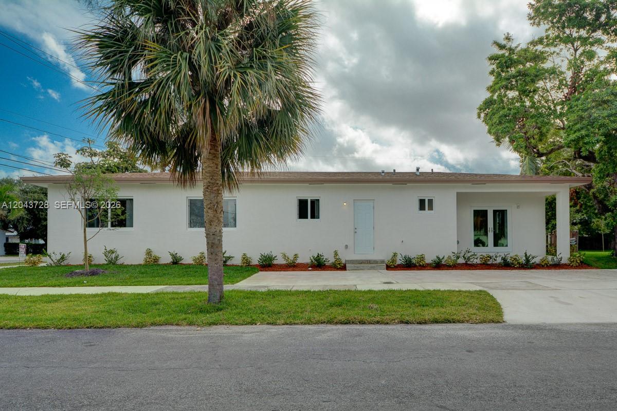 A single-story white house with a flat roof, a palm tree, and a concrete driveway — 312 Phippen Waiters Rd, Dania Beach FL 33004, DANIA BEACH, FL