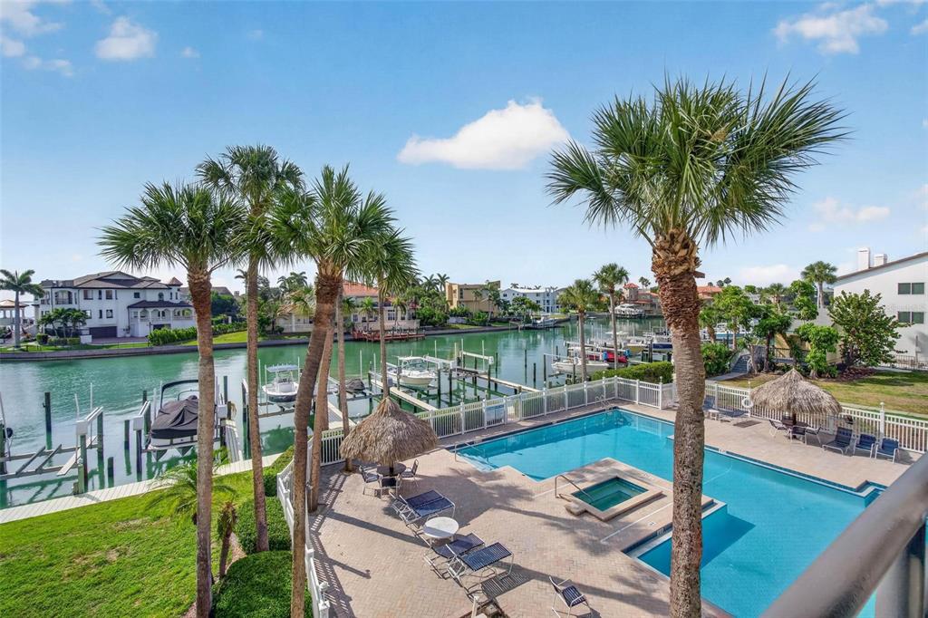An elevated view of a swimming pool and hot tub overlooking a canal with boats — 363 PINELLAS BAYWAY S UNIT 42, ST PETERSBURG, FL