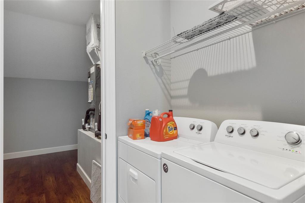 A laundry room features white appliances, a wire shelf, and an adjacent utility closet — 12752 S LAKE SAWYER LANE, WINDERMERE, FL