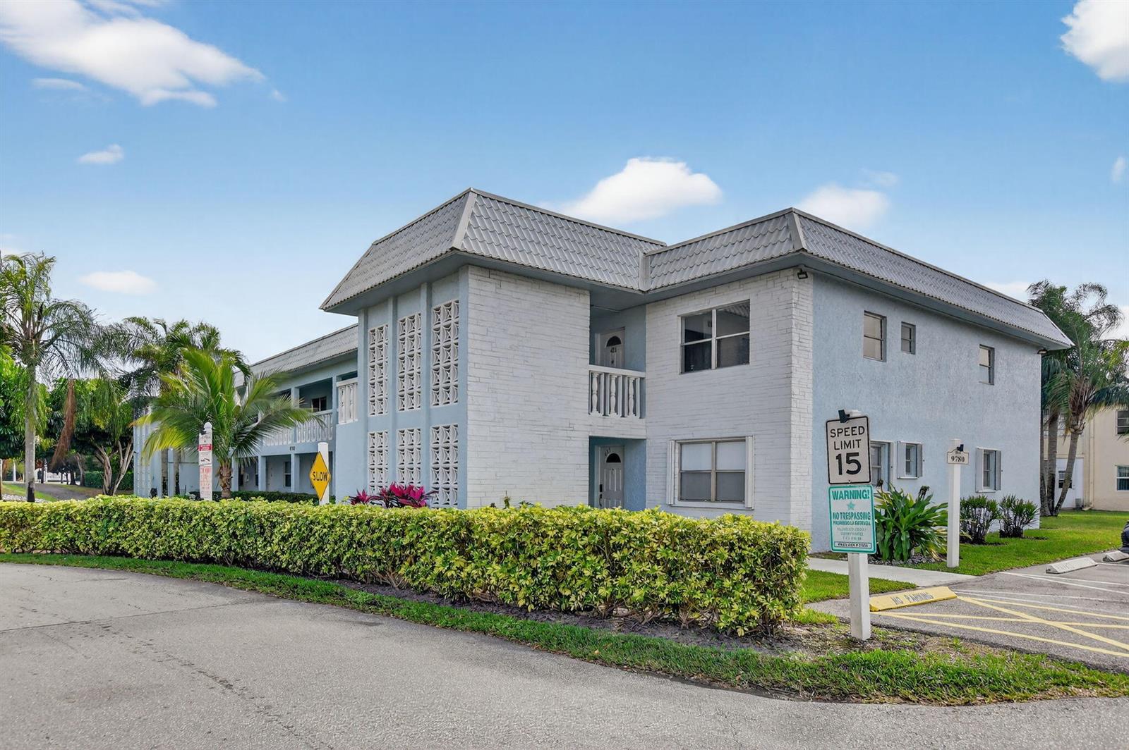 A two-story apartment building with light-colored brick siding and a metal roof — 9780 Marina Boulevard # 425, Boca Raton FL 33428, BOCA RATON, FL