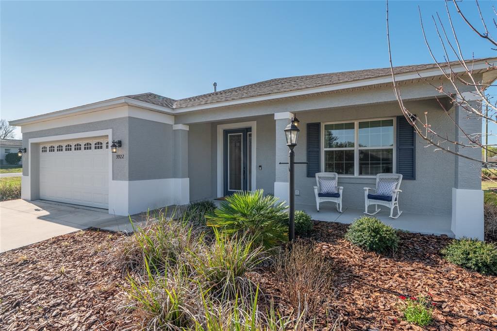 A single-story house with a gray stucco exterior, a two-car garage, and a front porch — 9922 SW 97TH LANE, OCALA, FL