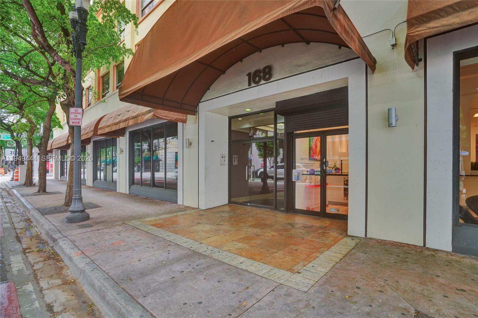 The exterior entrance of a commercial building features a brown awning and glass doors — 168 SE 1st St # 1200, Miami FL 33131, MIAMI, FL