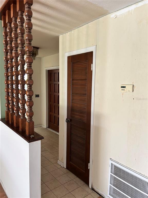 A room with wood-look flooring, a breakfast bar with three stools, and a ceiling fan — 7250 WOODBROOK DR, TAMPA, FL